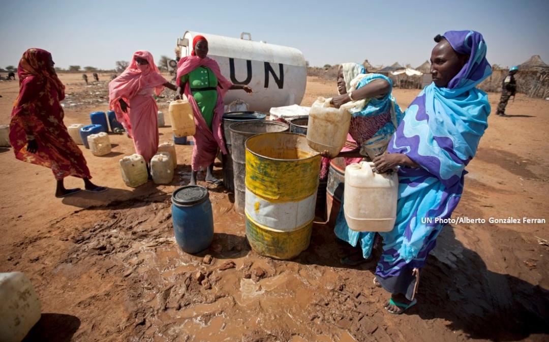 Women who were displaced after fleeing violence in their native Darfur villages collect water from a tank installed by UNAMID Sudan 